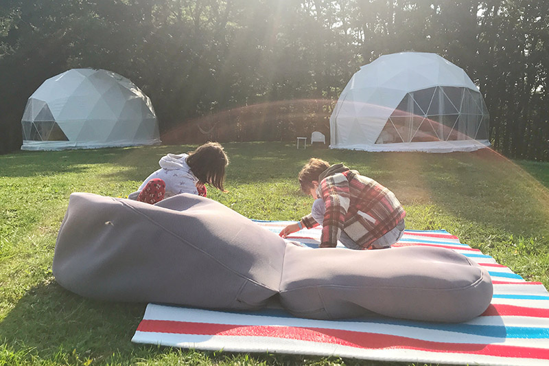 Diego e Bianca davanti a due delle bolle del Bubble Retreat in Umbria