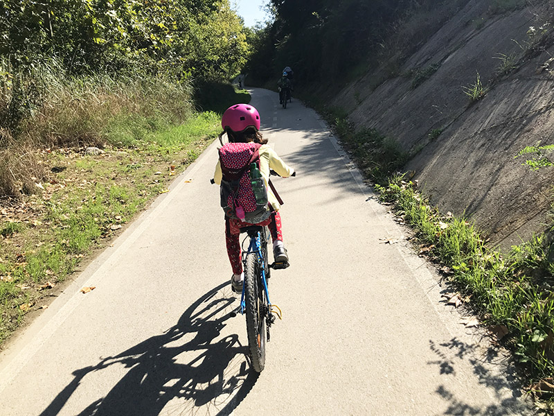 Bambina in bicicletta sul lungotevere